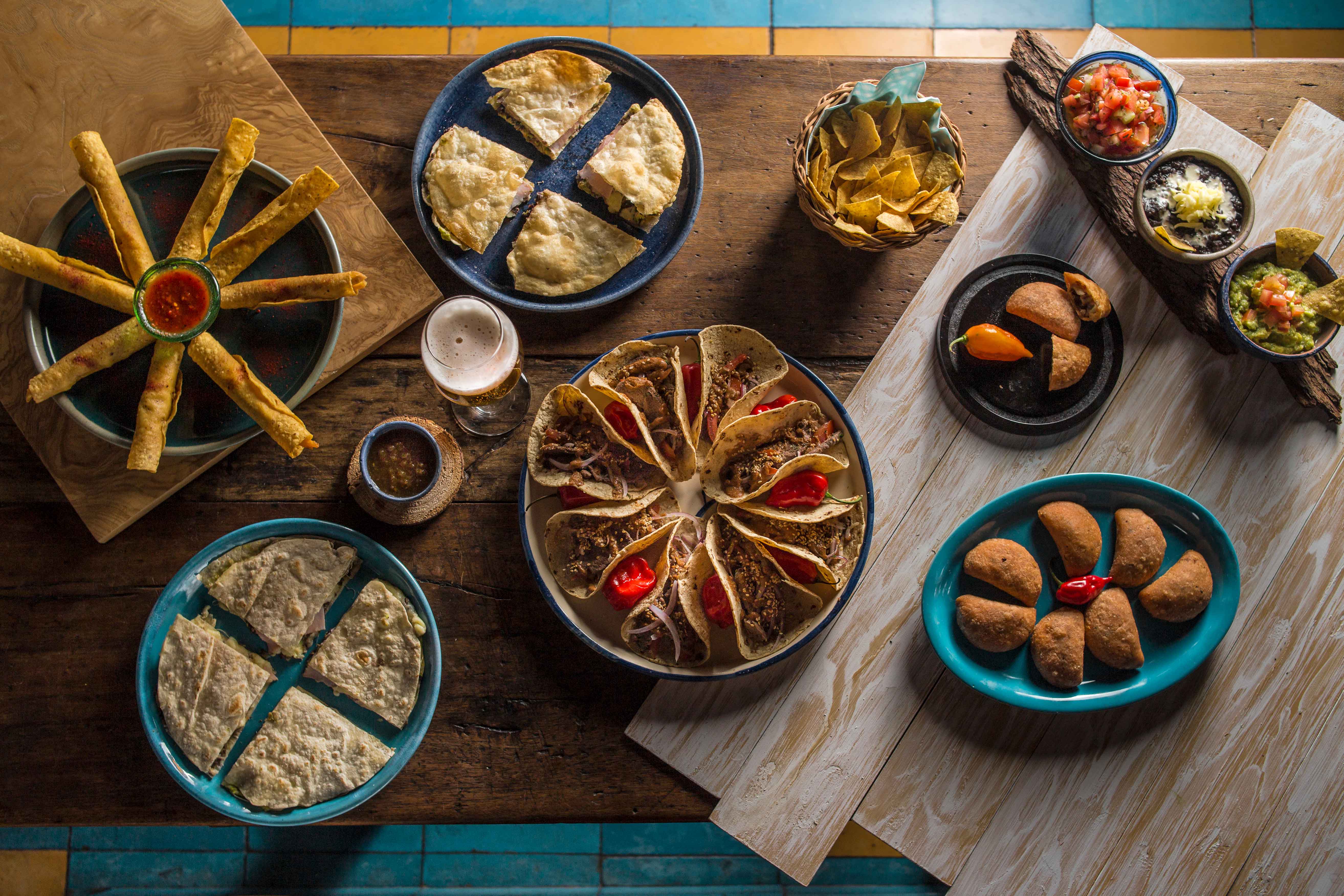 quesadillas de carne acompañadas de flautas totopos empanadas y tacos con pico de Gallo y guacamole.